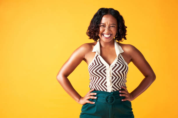 Happy women in front of a yellow background.