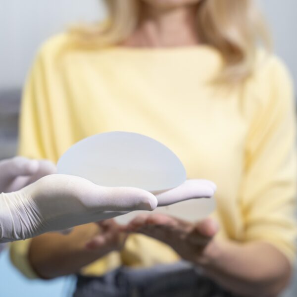 close up hands holding breast implant