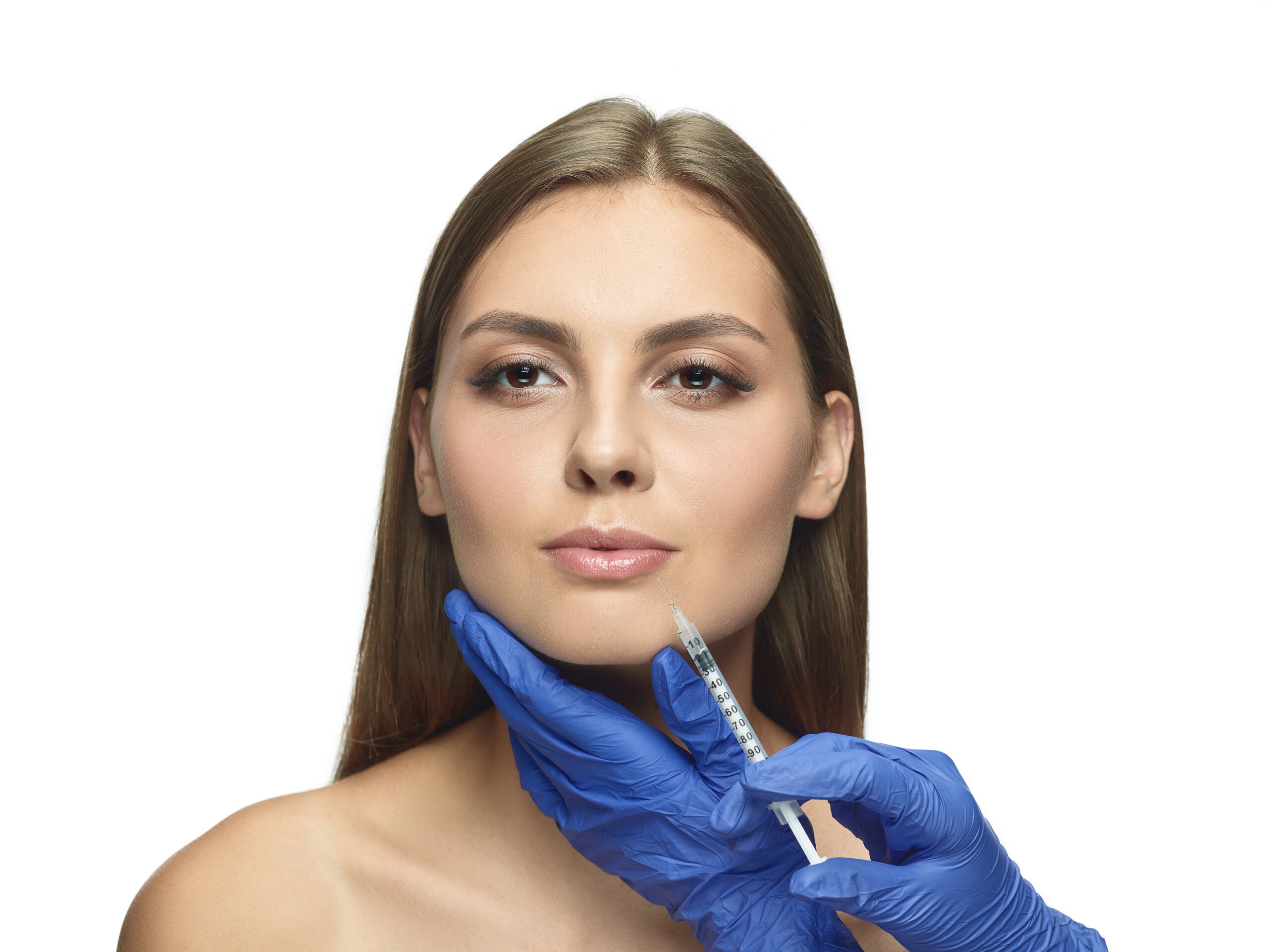 Close-up portrait of young woman on white studio background. Filling surgery procedure. Lip augmentation. Concept of women's health and beauty, cosmetology, self-care, body and skin care. Anti-aging.
