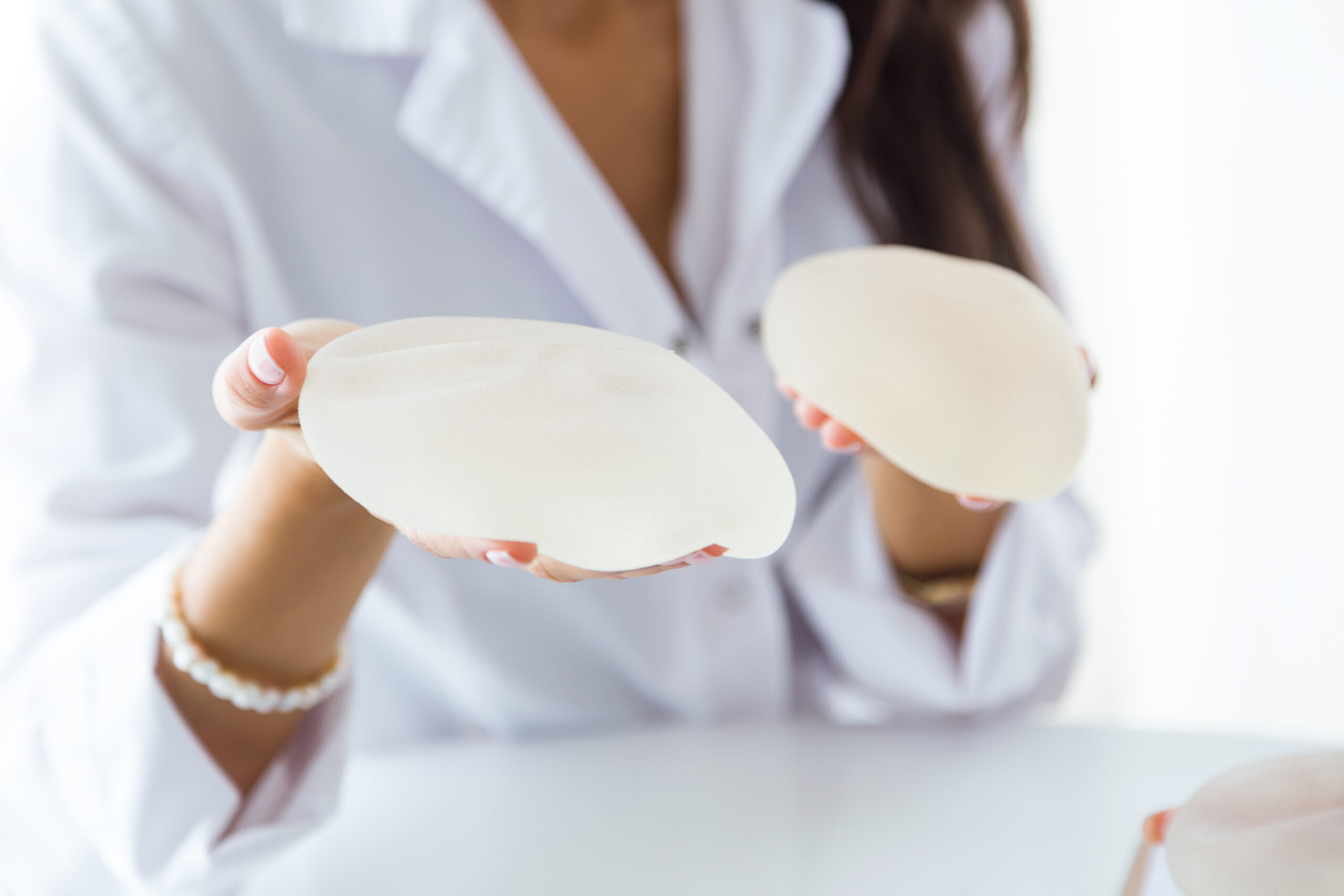 Female doctor choosing mammary prosthesis in the office for breast implant